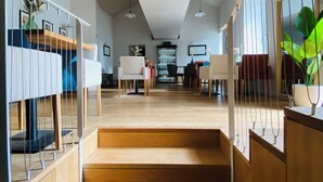 A modern interior with a staircase leading to a dining area, pendant lighting, and a view of the dining space. - Casa da Fonte de Cima (Celorico de Basto)