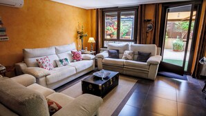A living room with two sofas, a coffee table, and a large window with a view of a garden. - El Refugio, Fuenmayor (Fuenmayor)