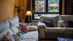 A living room with a sofa, a lamp, and a view of a garden through a window. - El Refugio, Fuenmayor (Fuenmayor)
