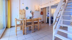 Ein Essbereich mit Holztisch und Stühlen, einer Uhr an der Wand und einer Gitarre.