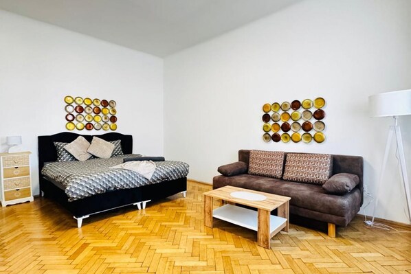 Une chambre à coucher comprenant un lit, un canapé, une table basse et deux œuvres d’art murales.