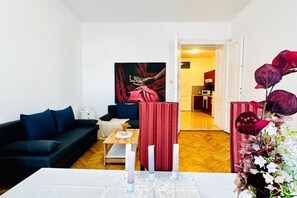 Uma sala de estar moderna com um sofá escuro, uma mesa de centro e um quadro na parede.