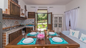 A dining area with a table set for four, a kitchen with a view, and a seating area with a sofa.