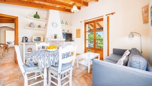 A cozy living area with a dining table, chairs, a sofa, a TV, and a fireplace.