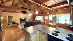 A spacious kitchen with wooden cabinets, a central island, and a stove.