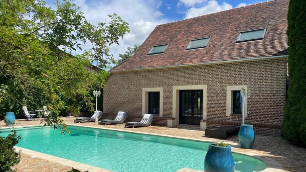 A brick house with a swimming pool, lounge chairs, and a patio area. - Gîtes de France® - Domaine Majorelle (LA BELLIERE)