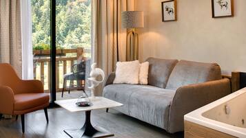 Habitación doble Deluxe, vista a la montaña | Área de sala de estar | Televisión de pantalla plana de 49 pulgadas con canales por cable