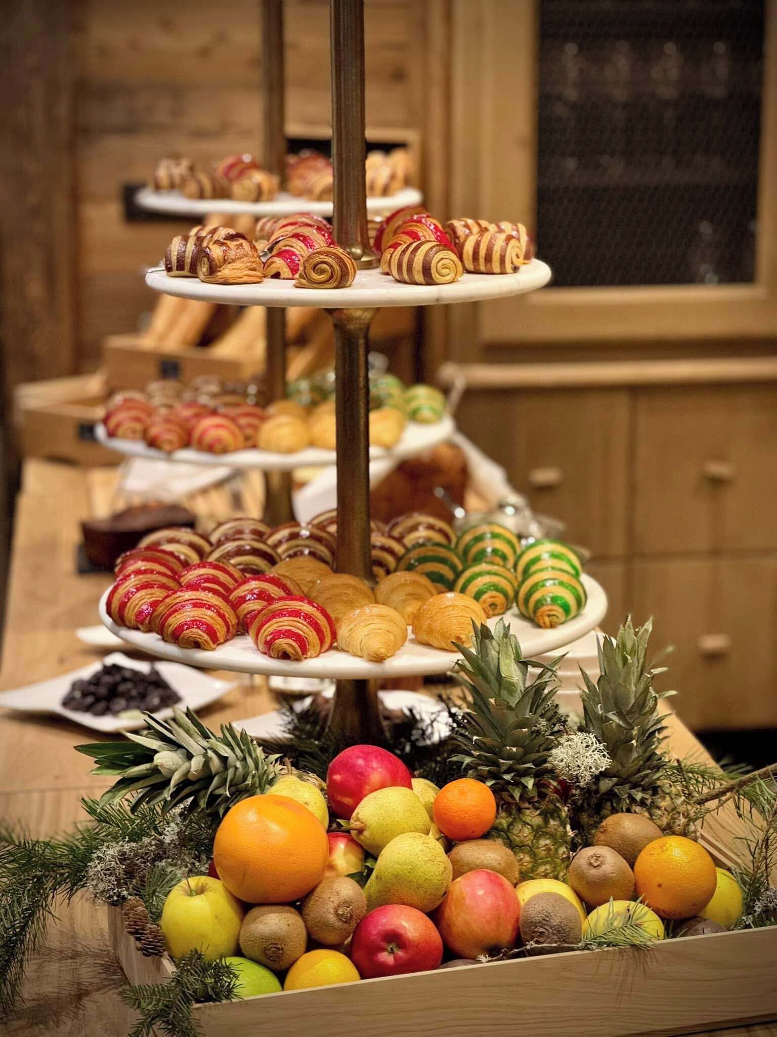 A buffet with a variety of pastries and fruits.