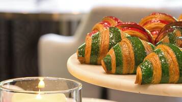 A table with croissants and a lit candle.