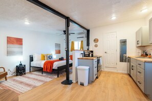 Een modern appartement met een bed, een kleine keuken en een badkamer.