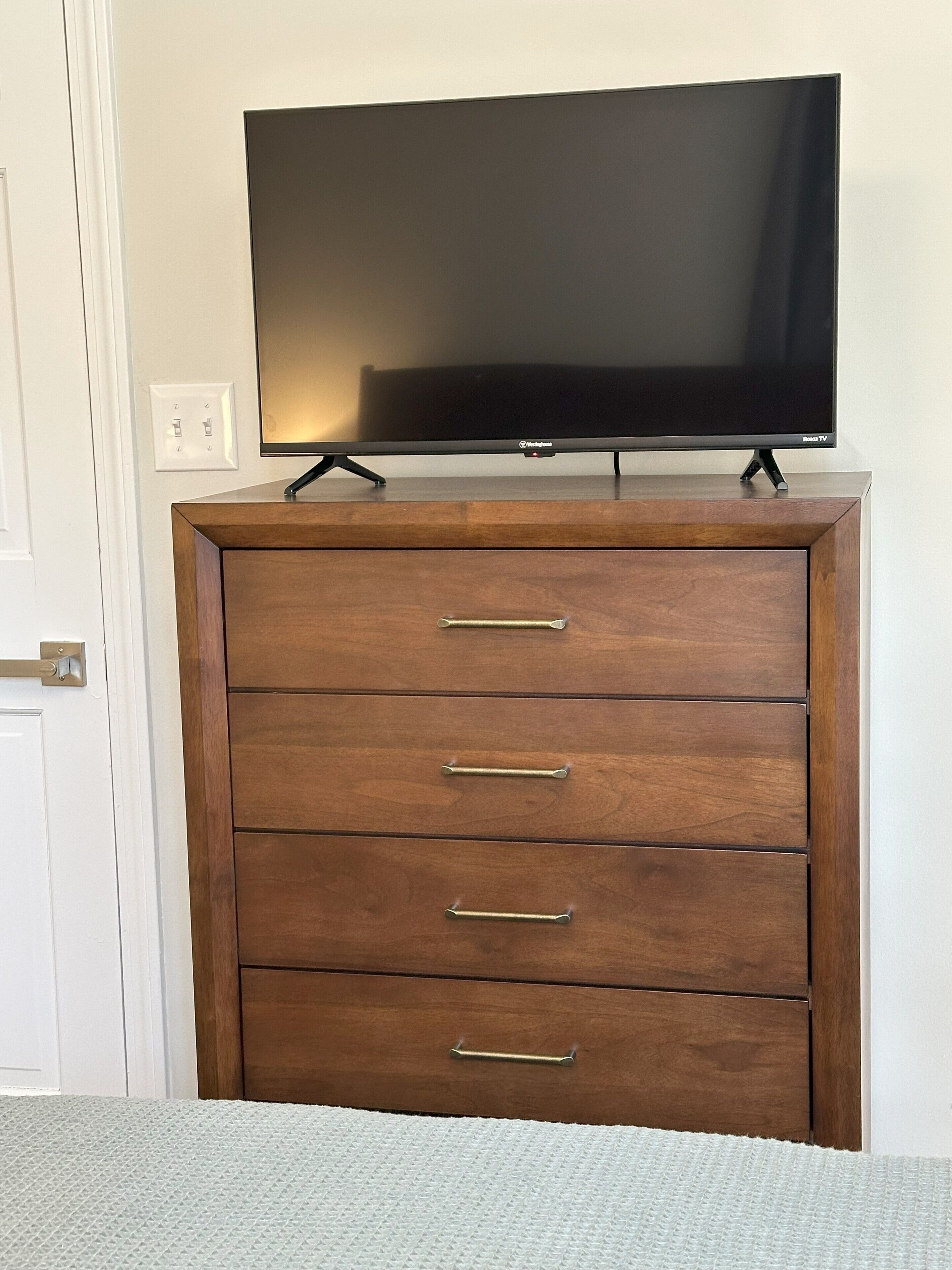 Un aparador de madera con un televisor de pantalla plana encima.