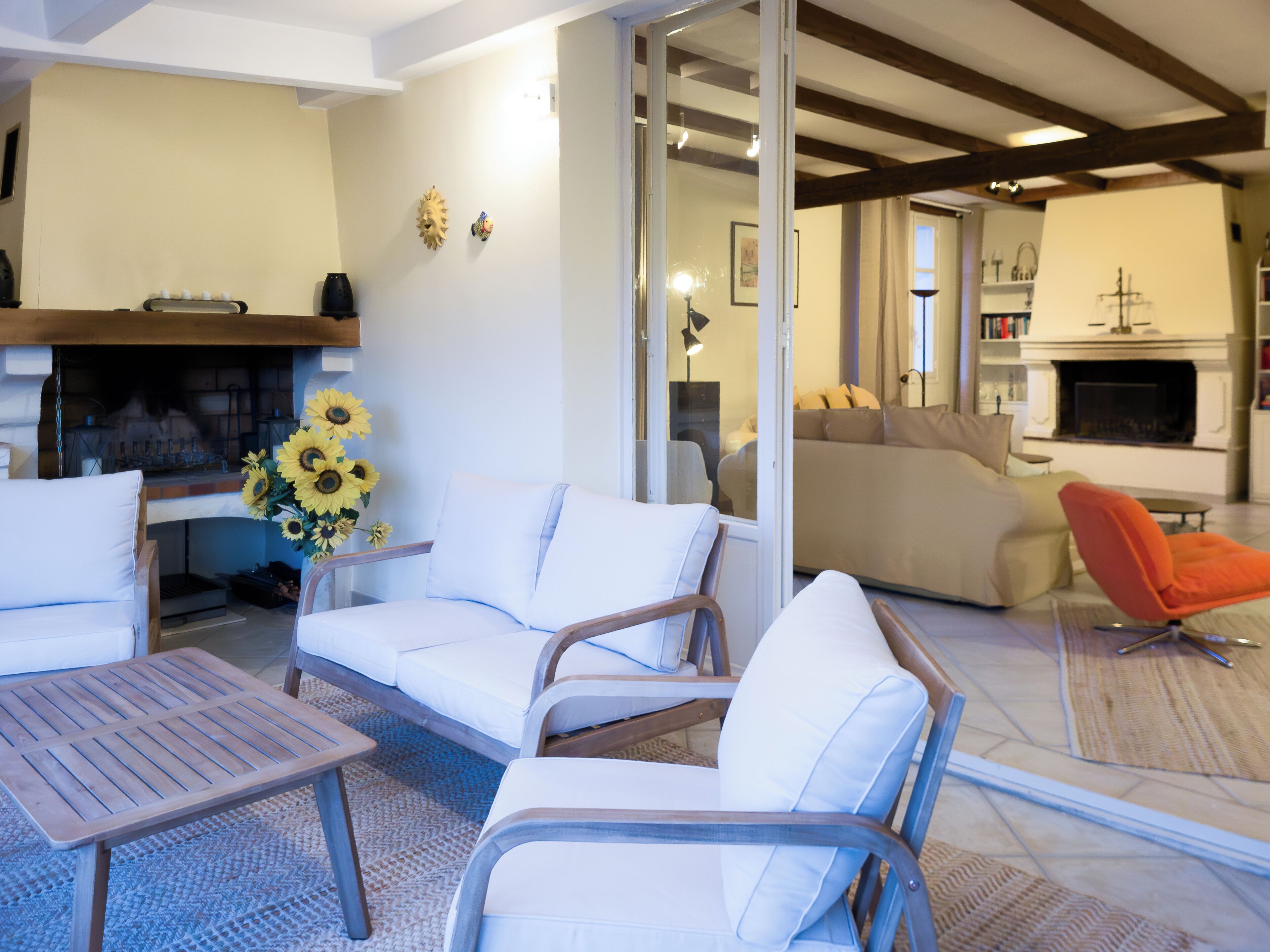 Un salon avec une cheminée, un canapé, une table basse et un fauteuil.