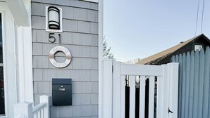 Une maison avec une petite clôture blanche, une boîte aux lettres et une plaque portant le numéro 51.