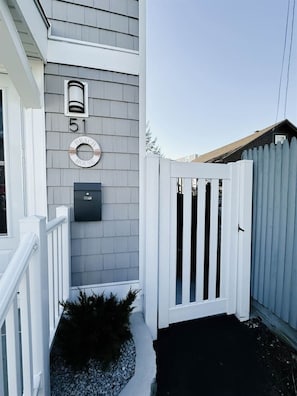 A house with a white picket gate, a mailbox, and a number 51 sign.