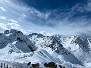 Un paysage montagneux enneigé, avec des affleurements rocheux et un ciel dégagé.