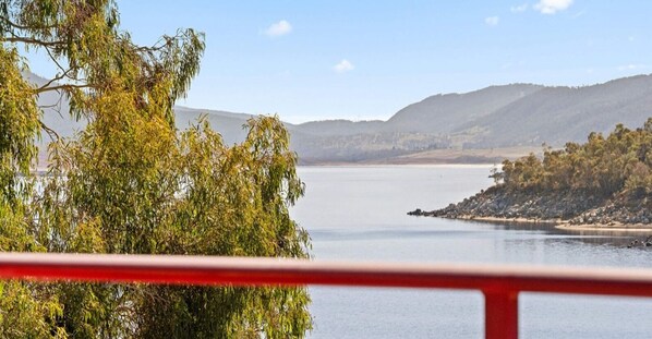 Enjoy breathtaking views of the serene lake and surrounding hills from the balcony.