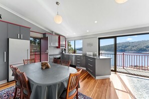 Enjoy meals at the large island with a sink and ample counter space, surrounded by cabinetry and a dining table with chairs.