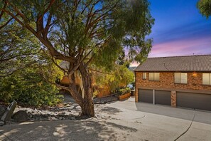 Set amidst mature trees, this two-story house offers a peaceful retreat with a garage and paved driveway.