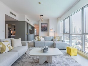 Een moderne woonkamer met een zithoek, een salontafel en een stadsgezicht door grote ramen.