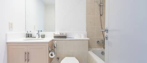 A modern bathroom with a toilet, sink, and shower.