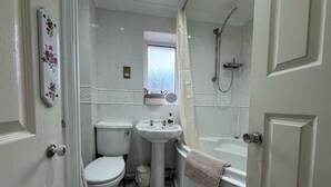 A bathroom with a toilet, sink, and bathtub.