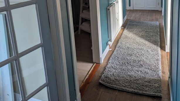 A hallway with a wooden floor, a grey carpet, and a white door at the end. - Cosy Annexe on The Isle of Skye. Family friendly, stunning vistas close to beach (Isle Of Skye)