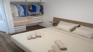 A bedroom with a bed, a wooden headboard, a built-in wardrobe, and a bedside table. - Los Diamantes 3 (Los Cristianos)