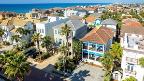 Un quartier résidentiel situé sur la côte, avec des maisons, des palmiers et une vue dégagée sur l’océan.
