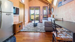A compact kitchen with a refrigerator, wooden cabinets, and a dining area with a table and chairs.