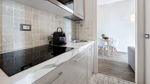 A modern kitchen with a built-in stove, a coffee maker, and a sink. - Apartment 'Garda Flow' with Wi-Fi and Air Conditioning (Lonato del Garda)