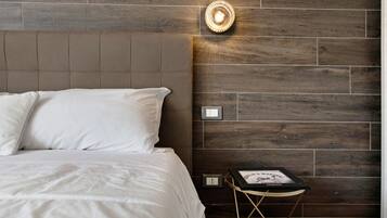 Ein Schlafzimmer mit einem Bett, einem Nachttisch und einer Wandleuchte.