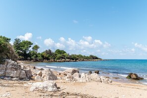 A beach with rocks, trees, and clear blue water. - Studio Apartment '1' with Private Terrace, Wi-Fi and Air Conditioning (Kalón Nerón)