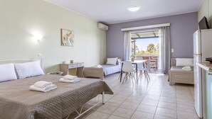 Ein Hotelzimmer mit Bett, Schreibtisch, Stuhl und einem Balkon mit Blick.