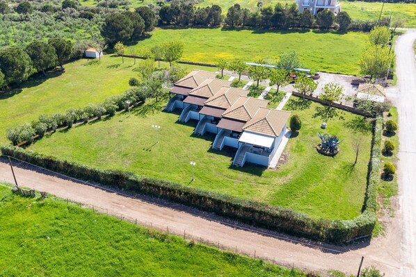 A large, rectangular property with a central building surrounded by a well-maintained lawn.