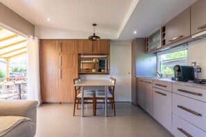 Une cuisine moderne avec des meubles en bois, une table à manger et une cuisinière intégrée.