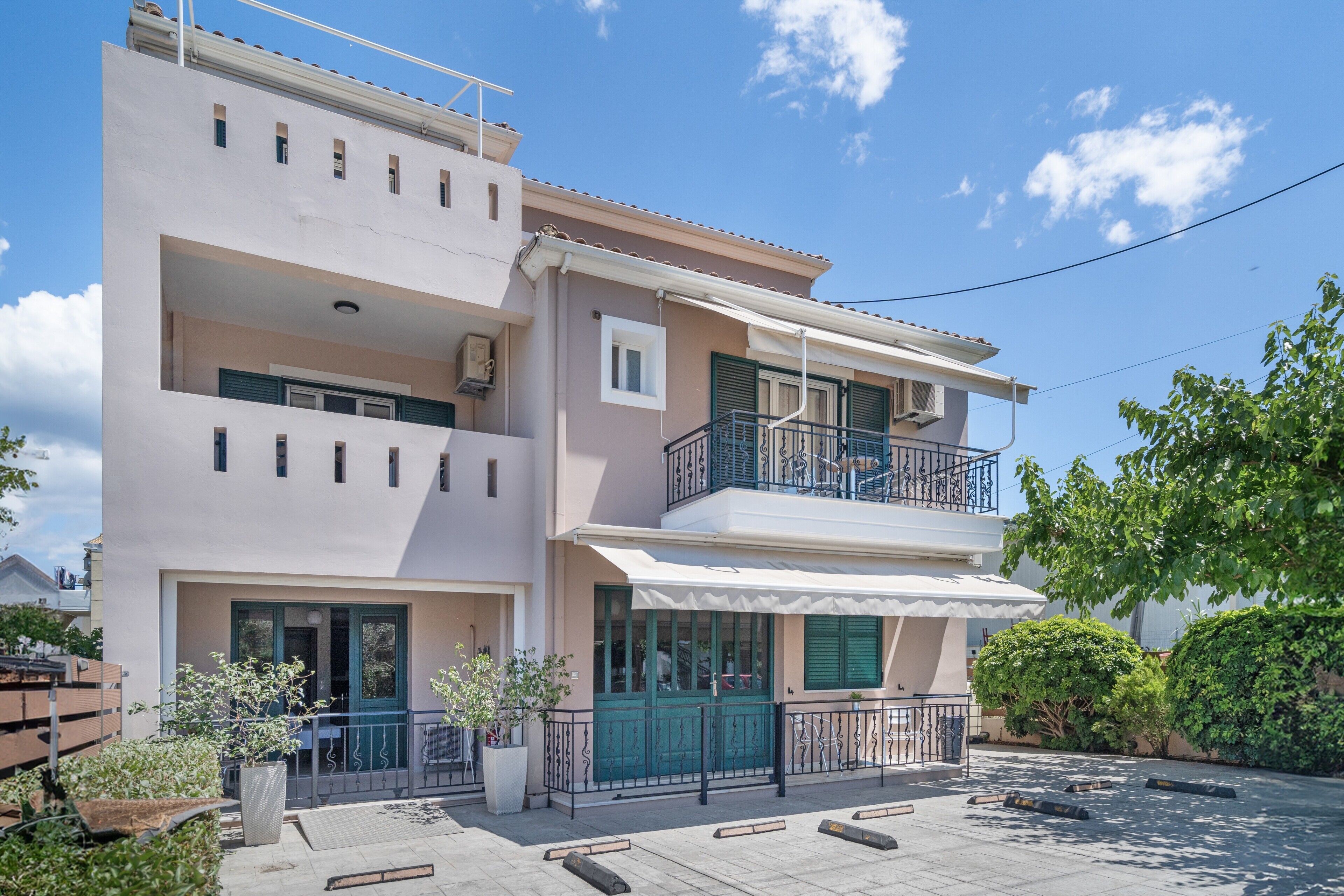 Un edificio residencial de varios pisos con balcones, ventanas amplias y un patio empedrado.
