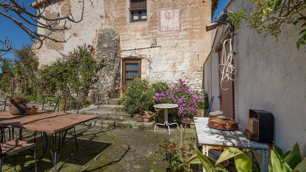 A rustic stone building with a courtyard, outdoor seating, and a small table with a pizza oven. - Country House 'Emilli' with Mountain View, Wi-Fi and Air Conditioning (Unknown)