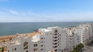 A coastal hotel with white architecture, a beach view, and a clear sky. - Apartment 'T2 2 Linha Praia Vista Mar' with Sea View, Balcony and Wi-Fi (Unknown)