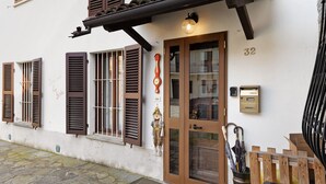 A building with a wooden door, brown shutters, and a mailbox. - Holiday Home 'Dello Zio Birba' with Balcony and Wi-Fi (Portacomaro)