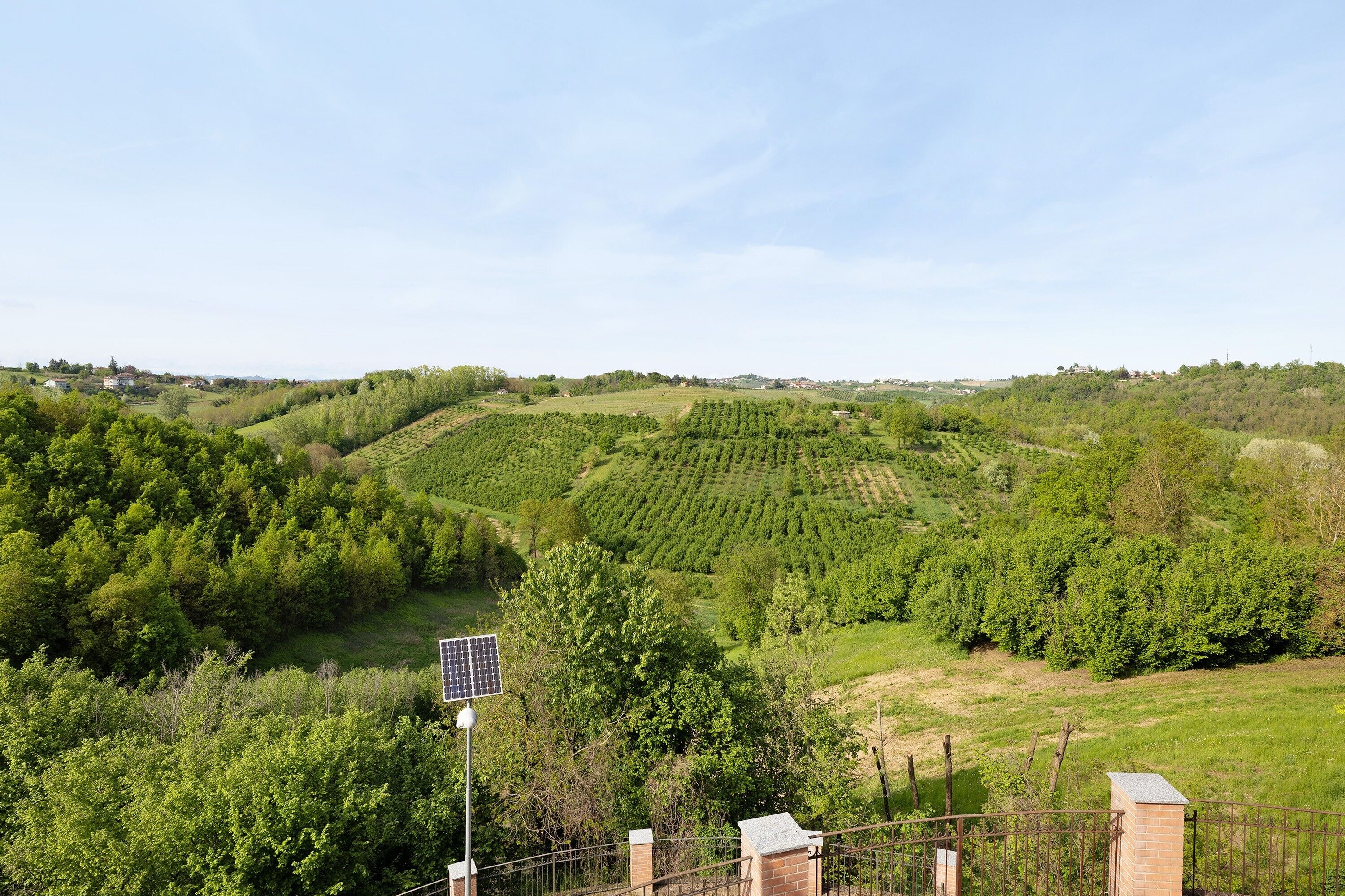 Un paysage rural caractérisé par des collines douces, une végétation luxuriante et un panneau solaire.