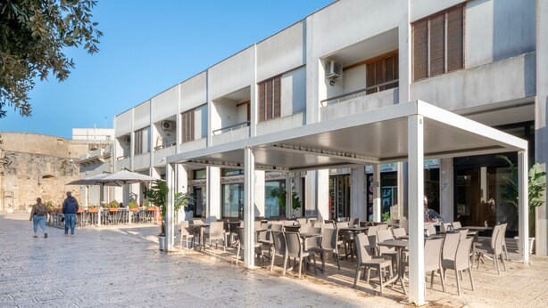 A building with outdoor seating, a stone wall, and a clear sky. - Apartment 'Stella' with Sea View, Wi-Fi and Air Conditioning (Otranto)