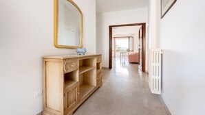 A hallway with a wooden cabinet, a mirror, and a radiator. - Apartment 'Stella' with Sea View, Wi-Fi and Air Conditioning (Otranto)