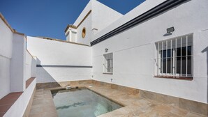 A white building with a swimming pool, a window with bars, and a small balcony. - Holiday Home 'Camposoto' with Private Pool, Wi-Fi and Air Conditioning (San Fernando)
