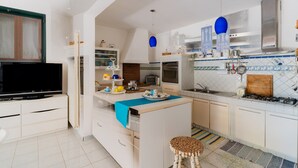 A modern kitchen with a TV, island, and various appliances.