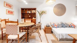 A cozy living room with a dining table, chairs, a bookshelf, a sofa, and a round wall decoration. - Casa Claper: Holiday Home with Shared Pool, Wi-Fi, and Air Conditioning (Unknown)