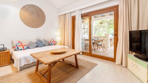 A bedroom with a bed, a wooden table, a TV, and a sliding glass door leading to a balcony. - Casa Claper: Holiday Home with Shared Pool, Wi-Fi, and Air Conditioning (Unknown)