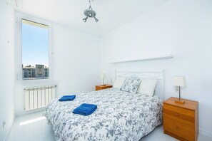A bedroom with a bed, two bedside tables, a window, and a ceiling fan. - Apartment 'La Plaza' on the Beach of Puerto de Pollensa with Wi-Fi and Air Conditioning (Unknown)