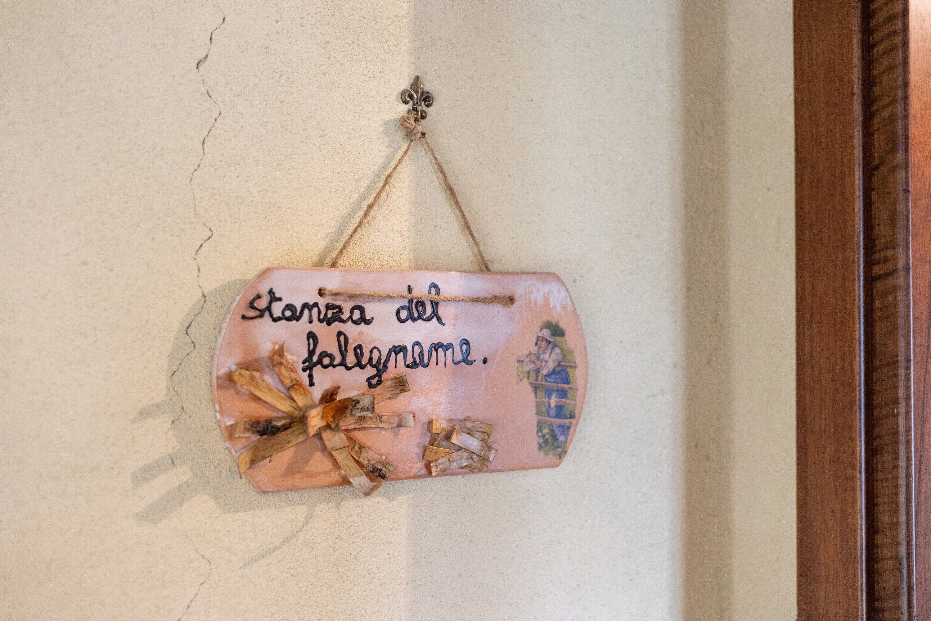 Un objet décoratif à accrocher au mur, orné d’un texte et d’un nœud.