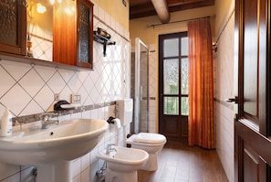 A bathroom with a sink, toilet, and shower area.