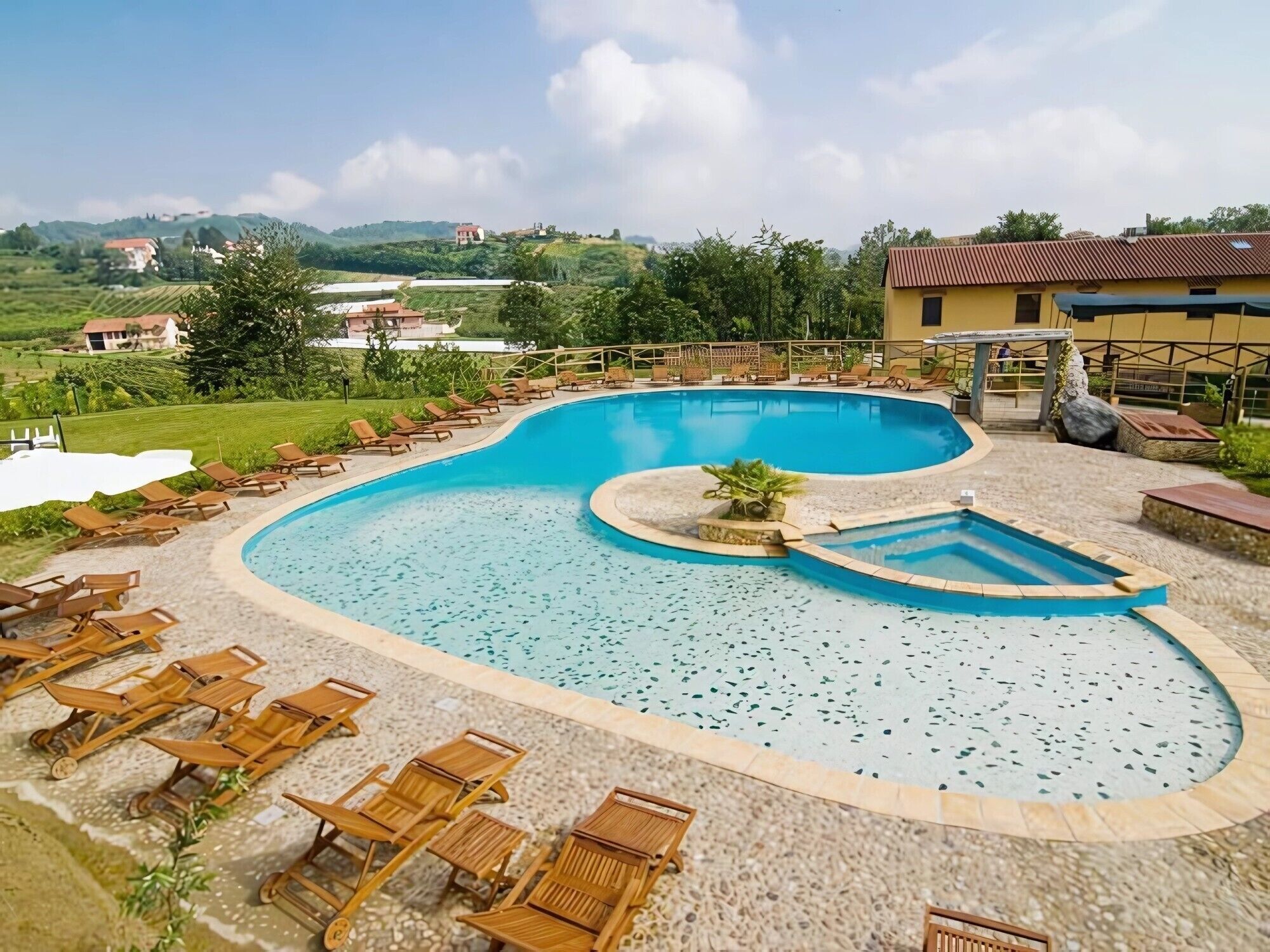 Une piscine dotée de chaises longues et offrant une vue sur le paysage environnant.
